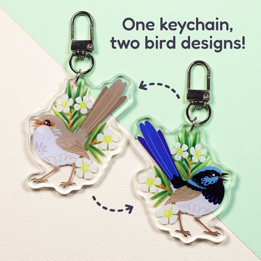 Both sides of a double-sided acrylic keychain of a male and female superb fairywren sitting on a split cream and pale green background with the text 'One keychain, two bird designs!' in the top right.