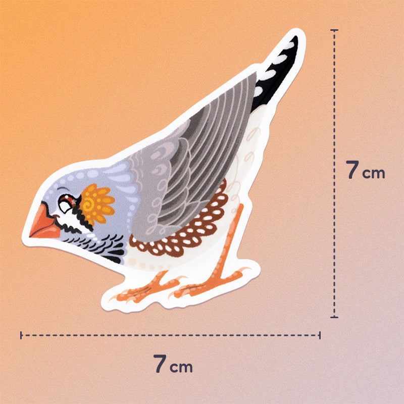 7x7cm colourful die-cut sticker of a male Australian zebra finch on a soft orange and beige gradient background.