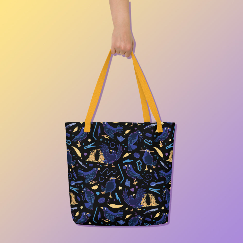 Hand holding a tote bag with yellow handles and a black/blue/yellow satin bowerbird pattern pattern on a yellow and purple gradient background.