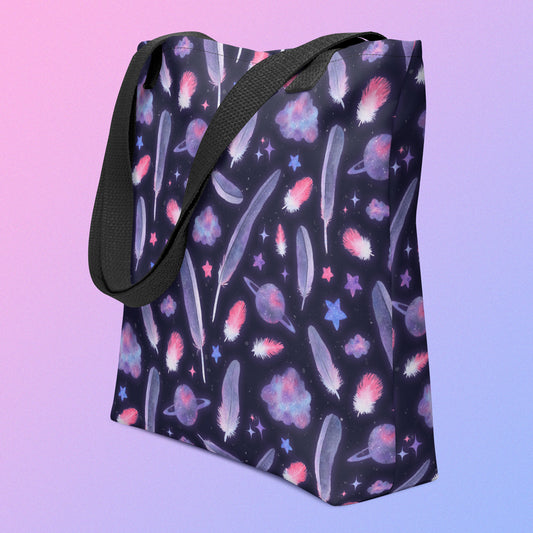 Tote bag with a black strap and galah cockatoo feather and galaxy-themed pattern on an angle on a gradient purple background