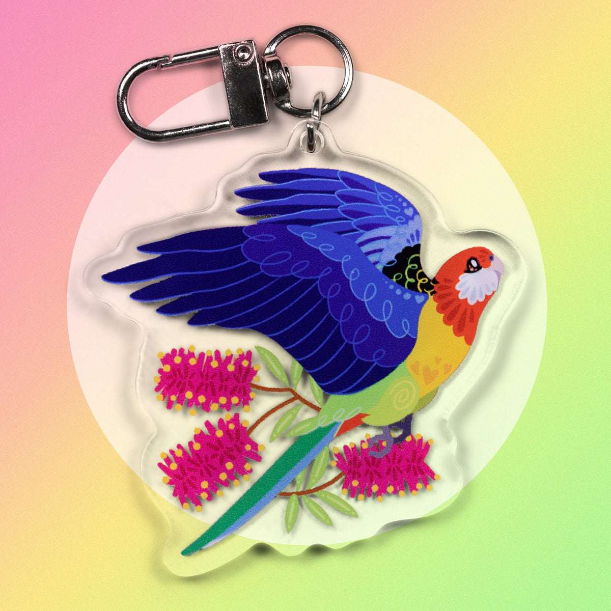 Double-sided acrylic keychain of crimson & eastern rosellas sitting on a pink, yellow and green gradient background.