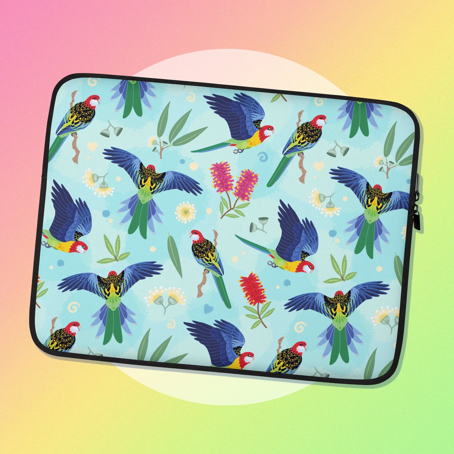 A zipped laptop sleeve with an eastern rosella pattern on a white circle on a pink, yellow and green gradient background.