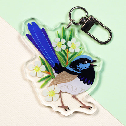 Double-sided acrylic keychain of a male and female superb fairywren sitting on a split cream and pale green background.