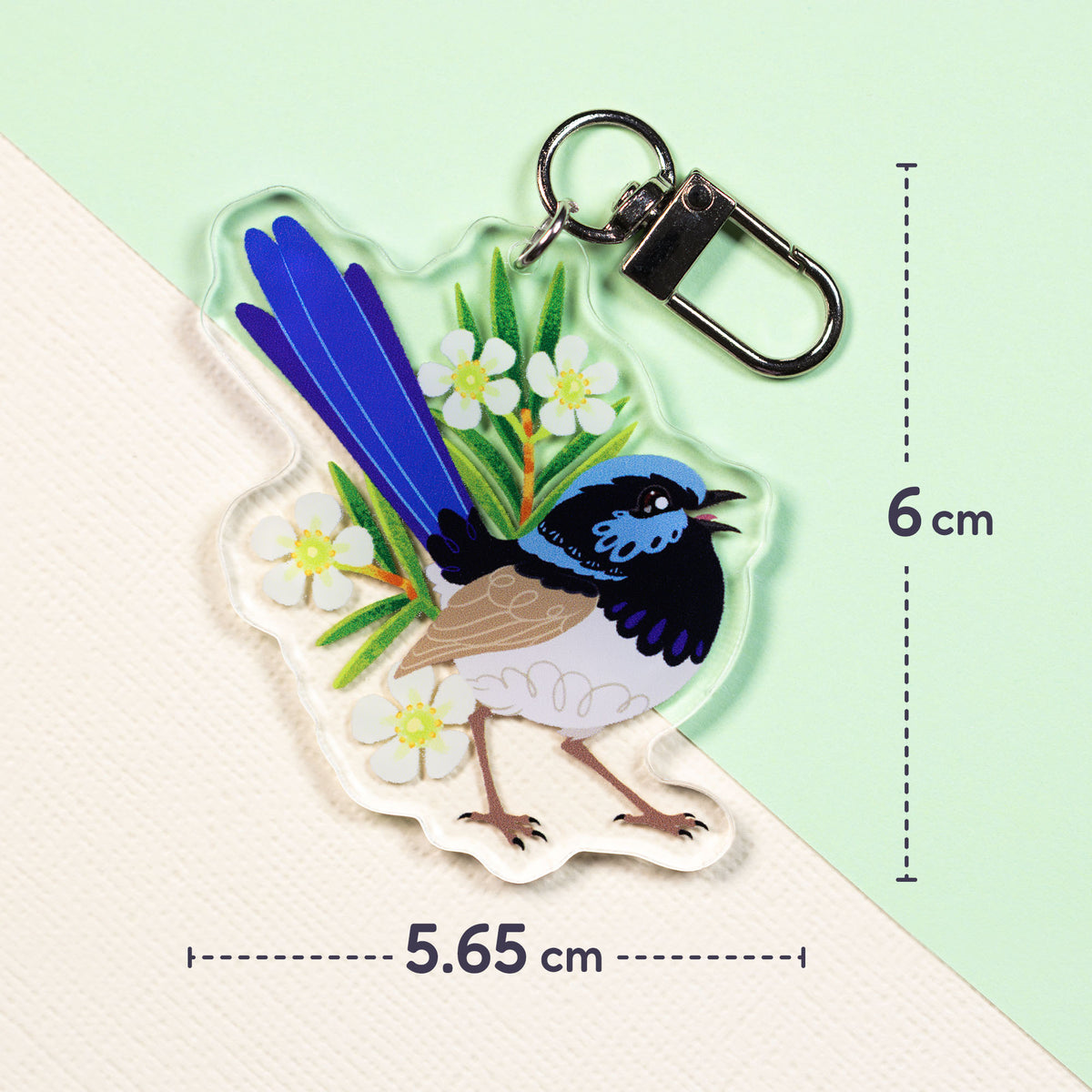 5.65 x 6cm double-sided acrylic keychain of a male and female superb fairywren sitting on a split cream and pale green background.