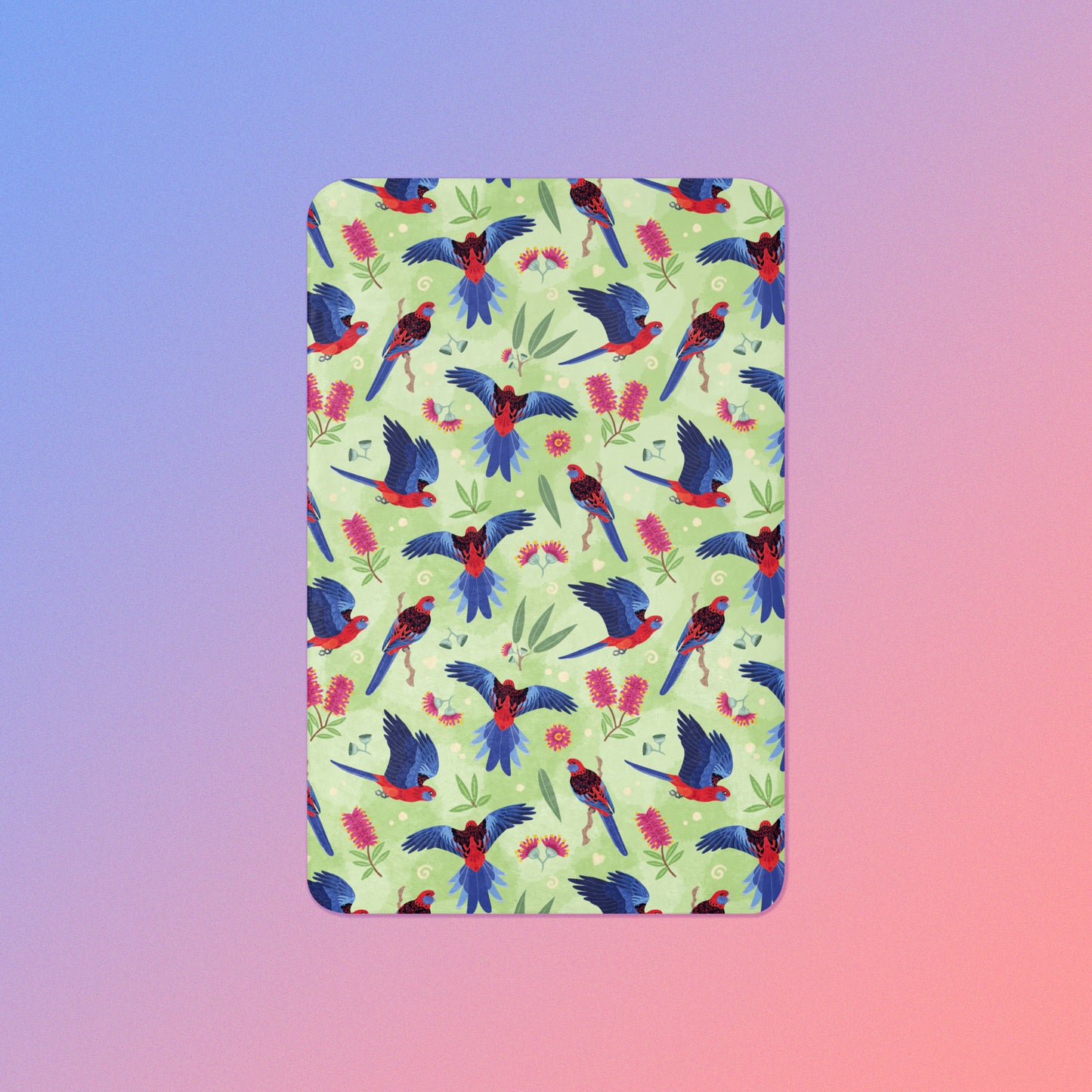 A green, red and blue crimson rosella & native Aussie plant pattern blanket on a blue and pink gradient background.
