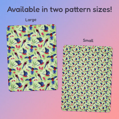 Side-by-side comparison of two pattern print sizes (Large & Small) of a green, red and blue crimson rosella & native Aussie plant pattern blanket on a blue and pink gradient background.