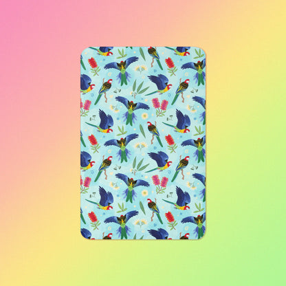 A blue, pink and green eastern rosella & native Aussie plant pattern blanket on a pink, yellow and green gradient background.
