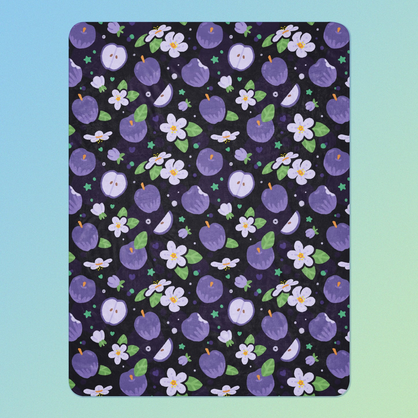 A purple apples & blossoms pattern blanket on a blue and green gradient background.