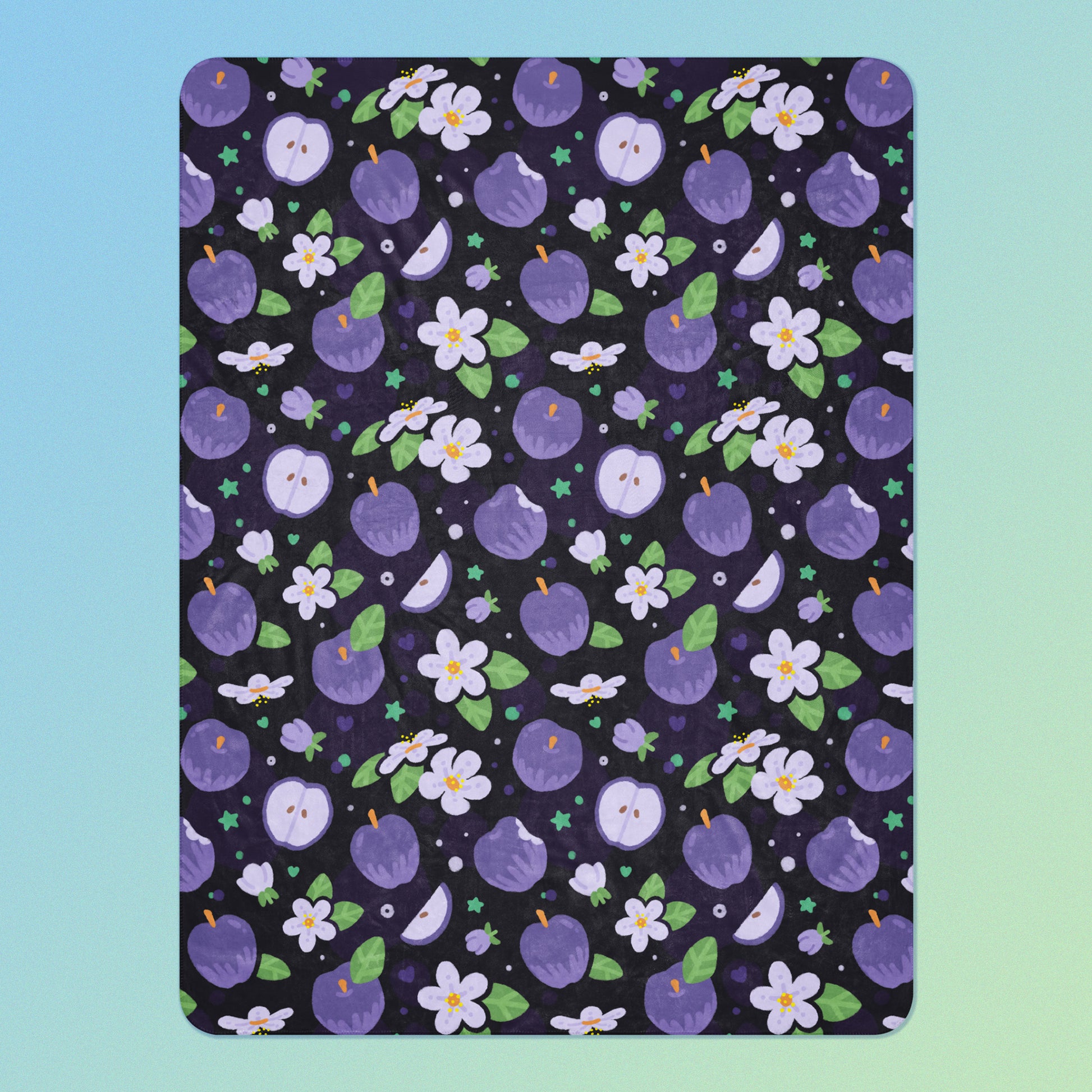 A purple apples & blossoms pattern blanket on a blue and green gradient background.