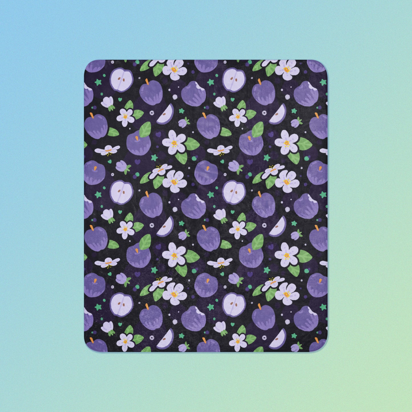 A purple apples & blossoms pattern blanket on a blue and green gradient background.