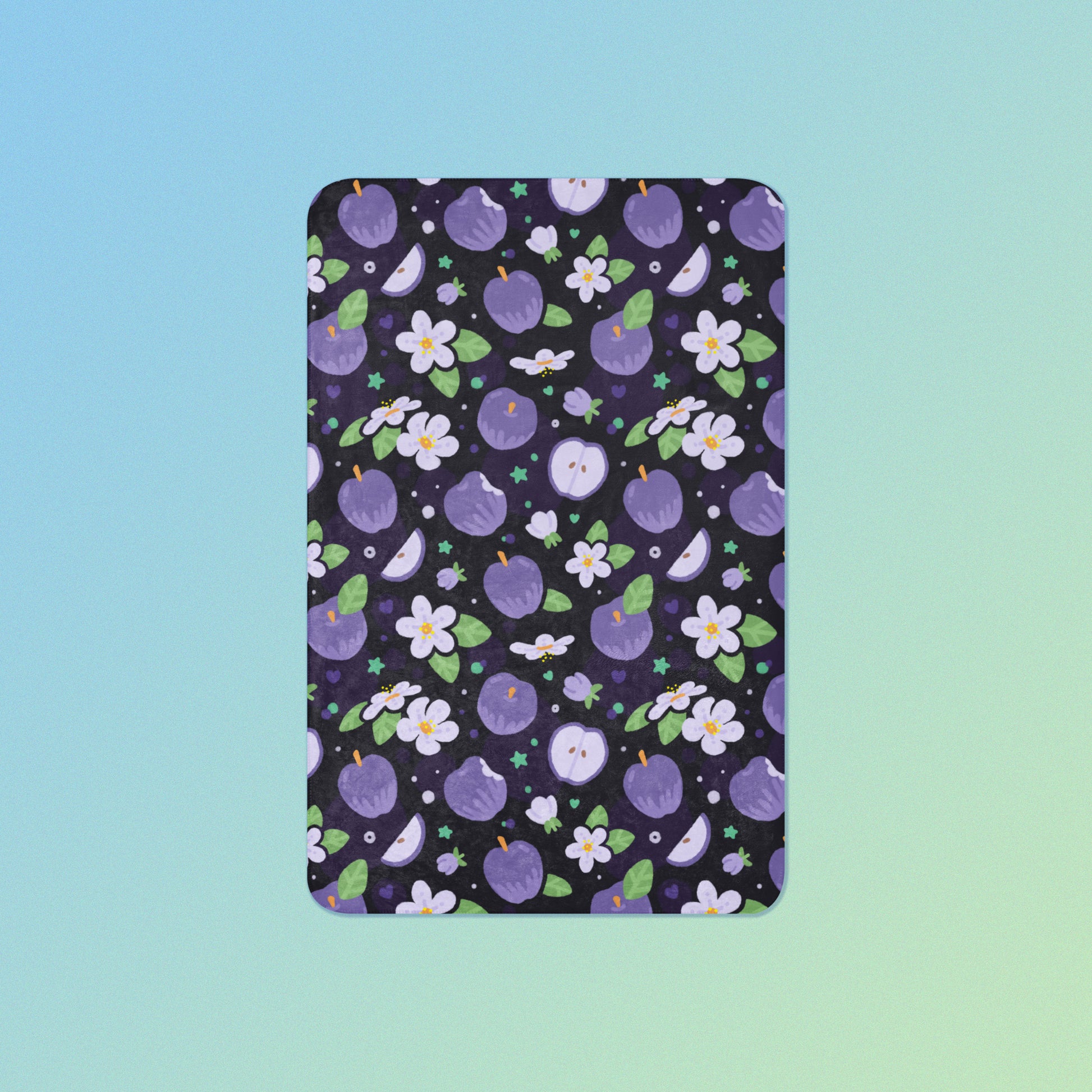 A purple apples & blossoms pattern blanket on a blue and green gradient background.