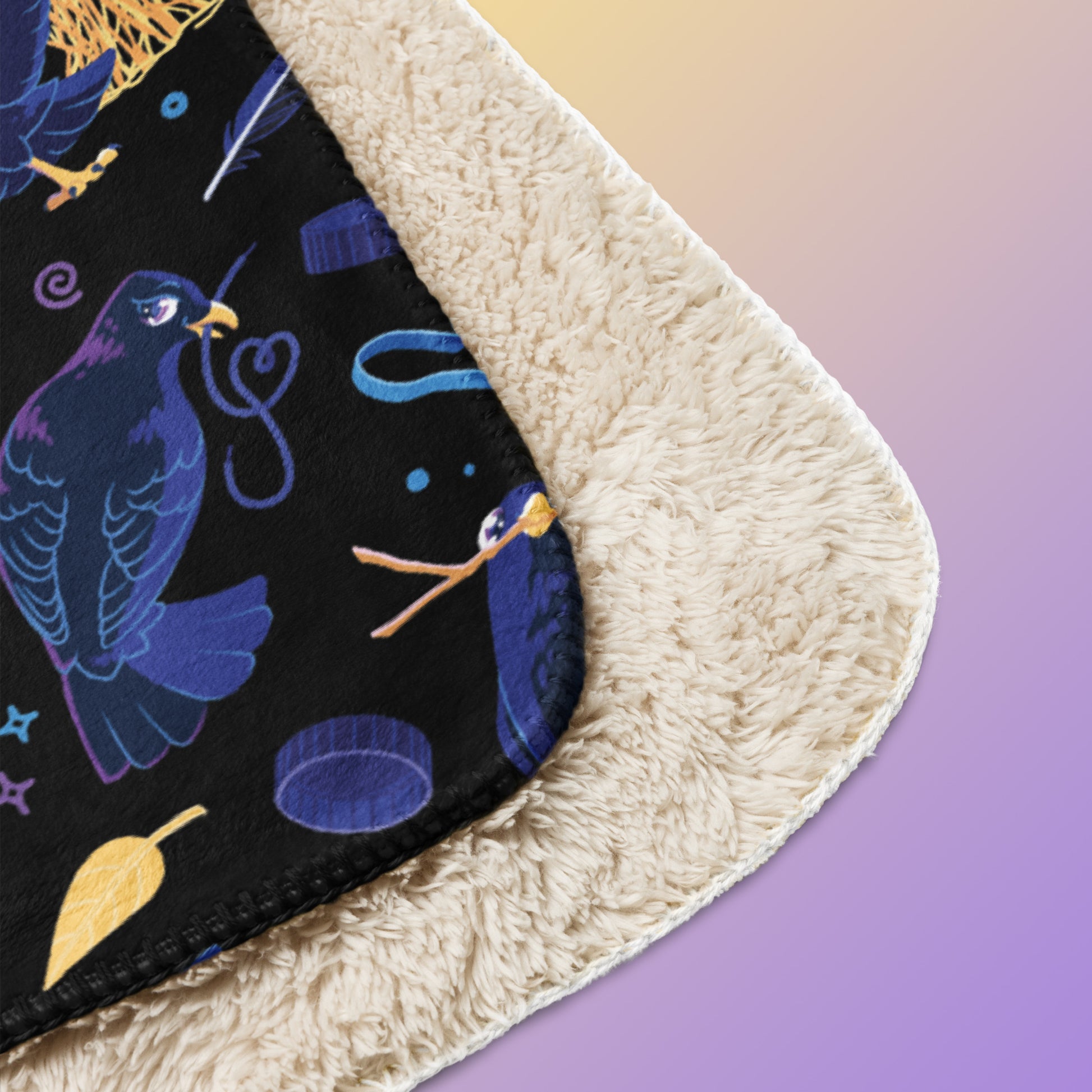 Close up detail of a folded black, blue, purple and yellow male Aussie satin bowerbird pattern blanket on a yellow and purple gradient background.