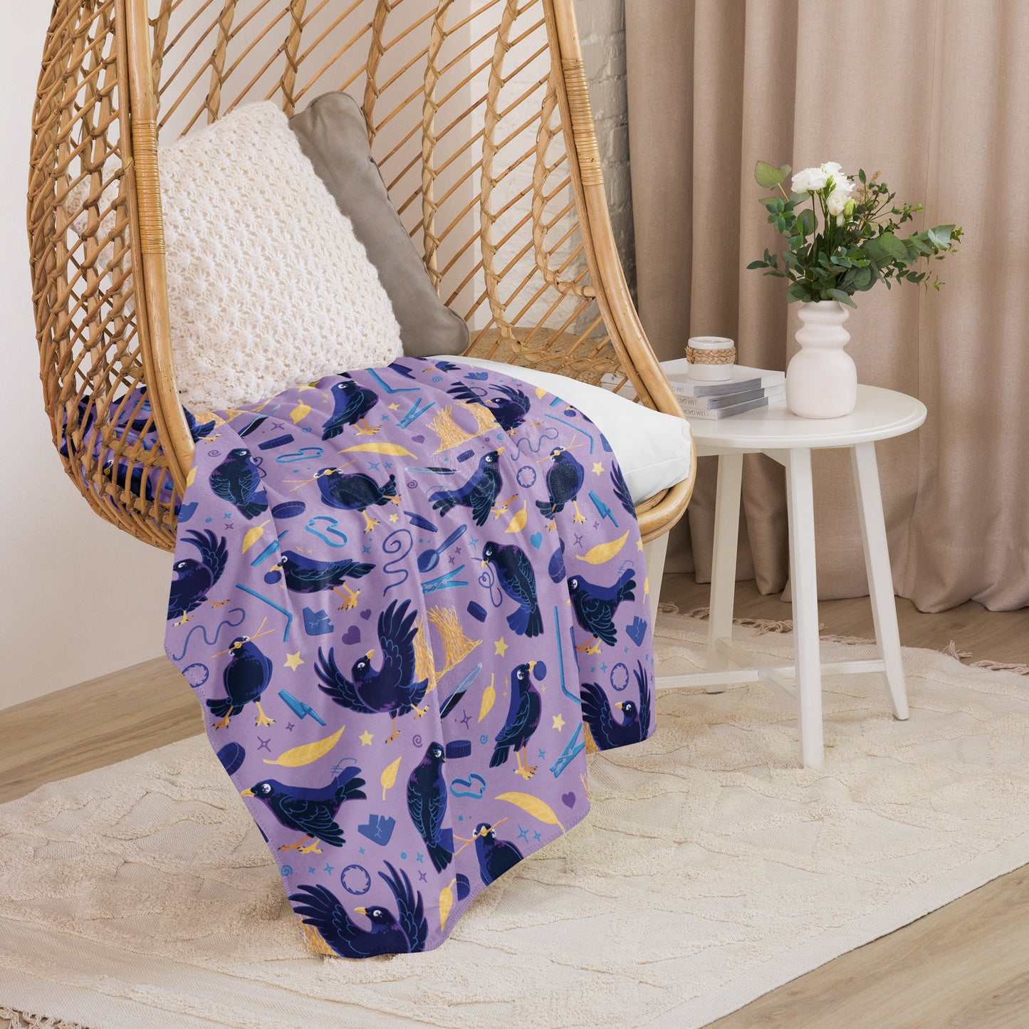 A purple, blue and yellow male Aussie satin bowerbird pattern blanket sitting on a swinging woven egg chair with soft, natural lighting.