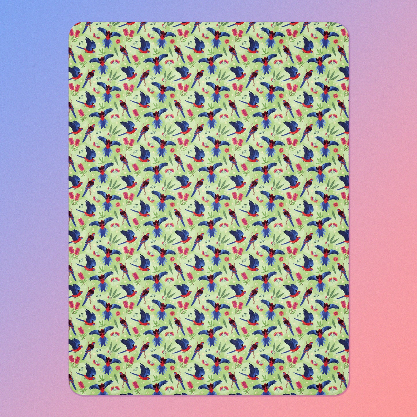 A green, red and blue crimson rosella & native Aussie plant pattern blanket on a blue and pink gradient background.