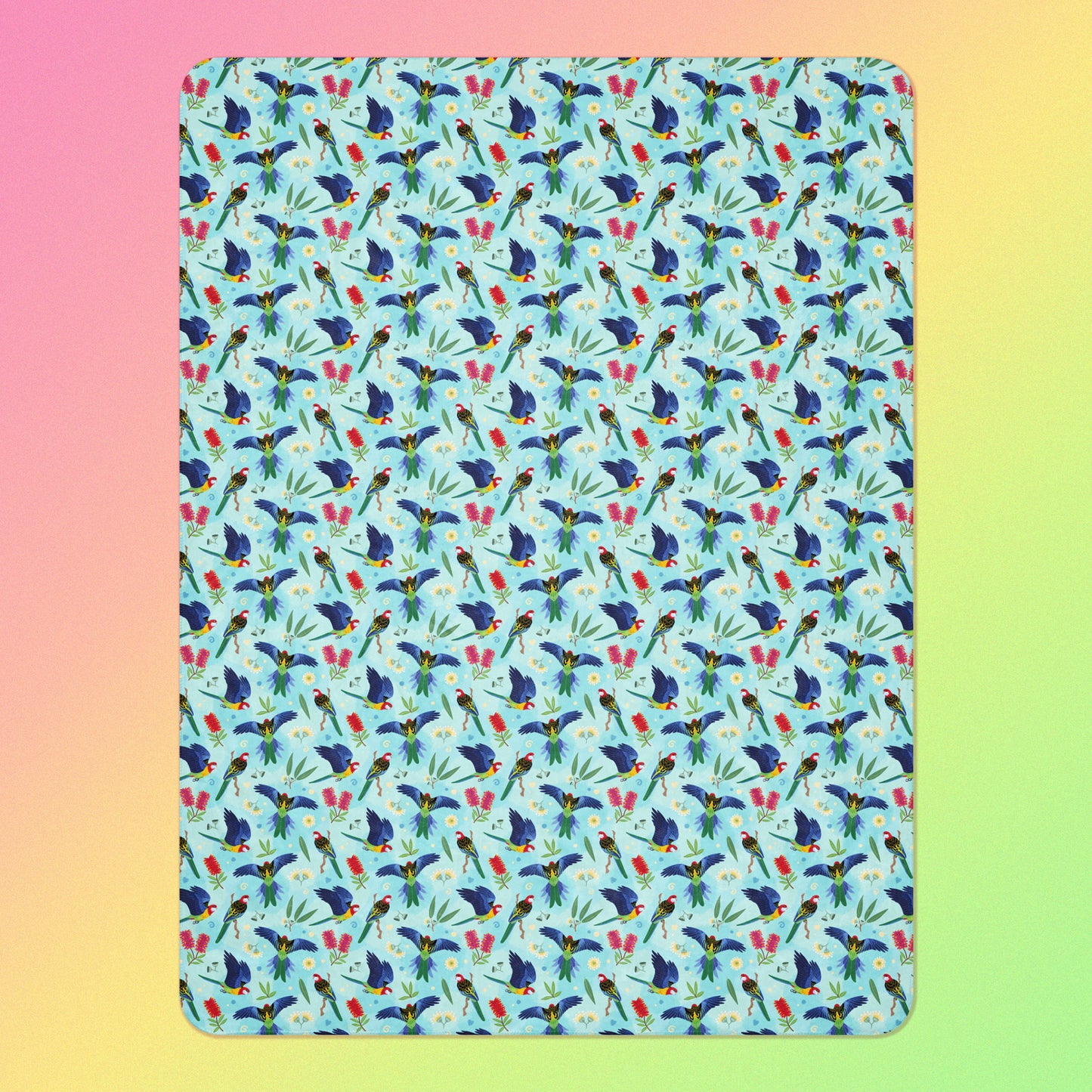 A blue, pink and green eastern rosella & native Aussie plant pattern blanket on a pink, yellow and green gradient background.