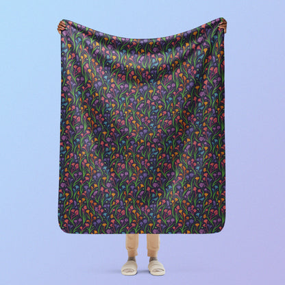 Person holding a rainbow kangaroo paw flower pattern blanket above their head on a blue and purple gradient background.