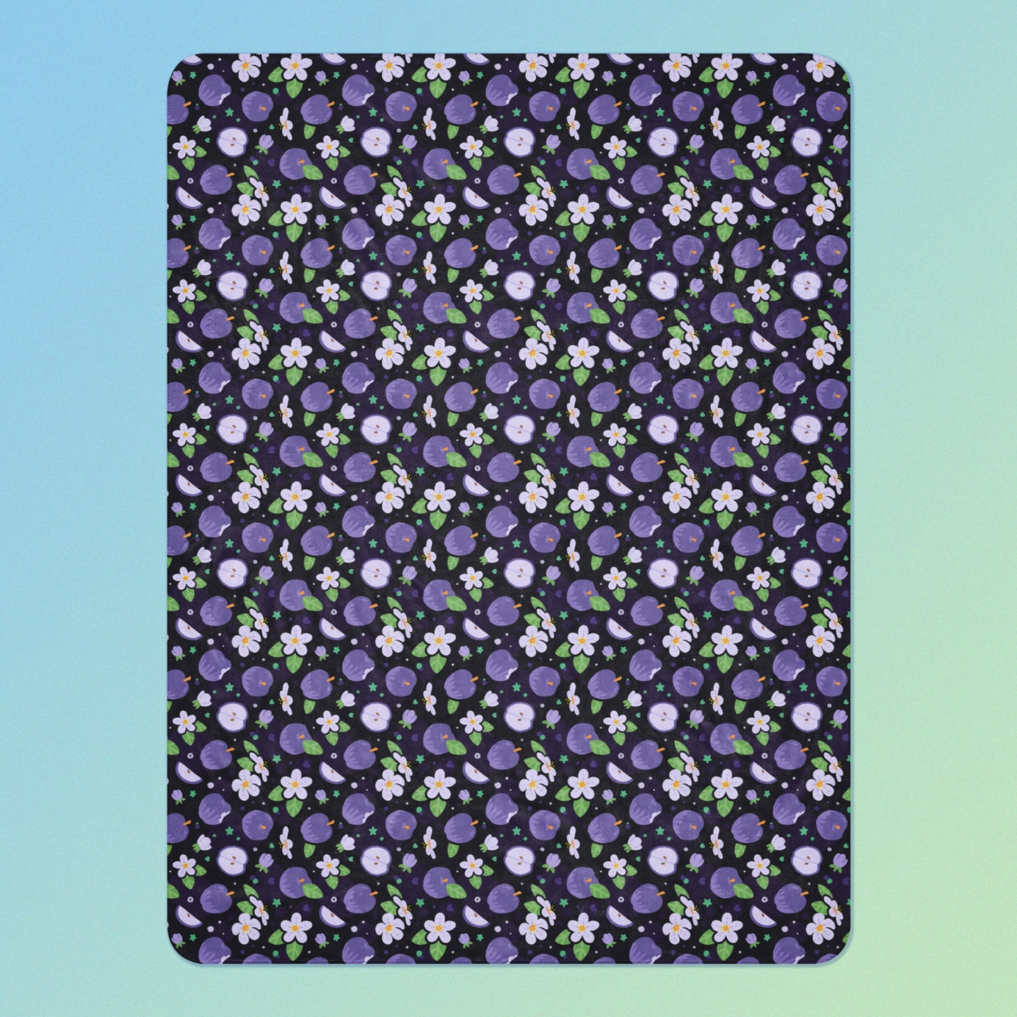 A purple apples & blossoms pattern blanket on a blue and green gradient background.