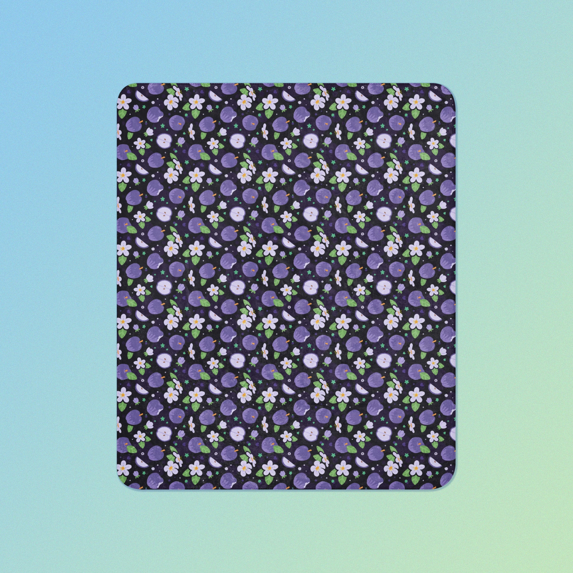 A purple apples & blossoms pattern blanket on a blue and green gradient background.