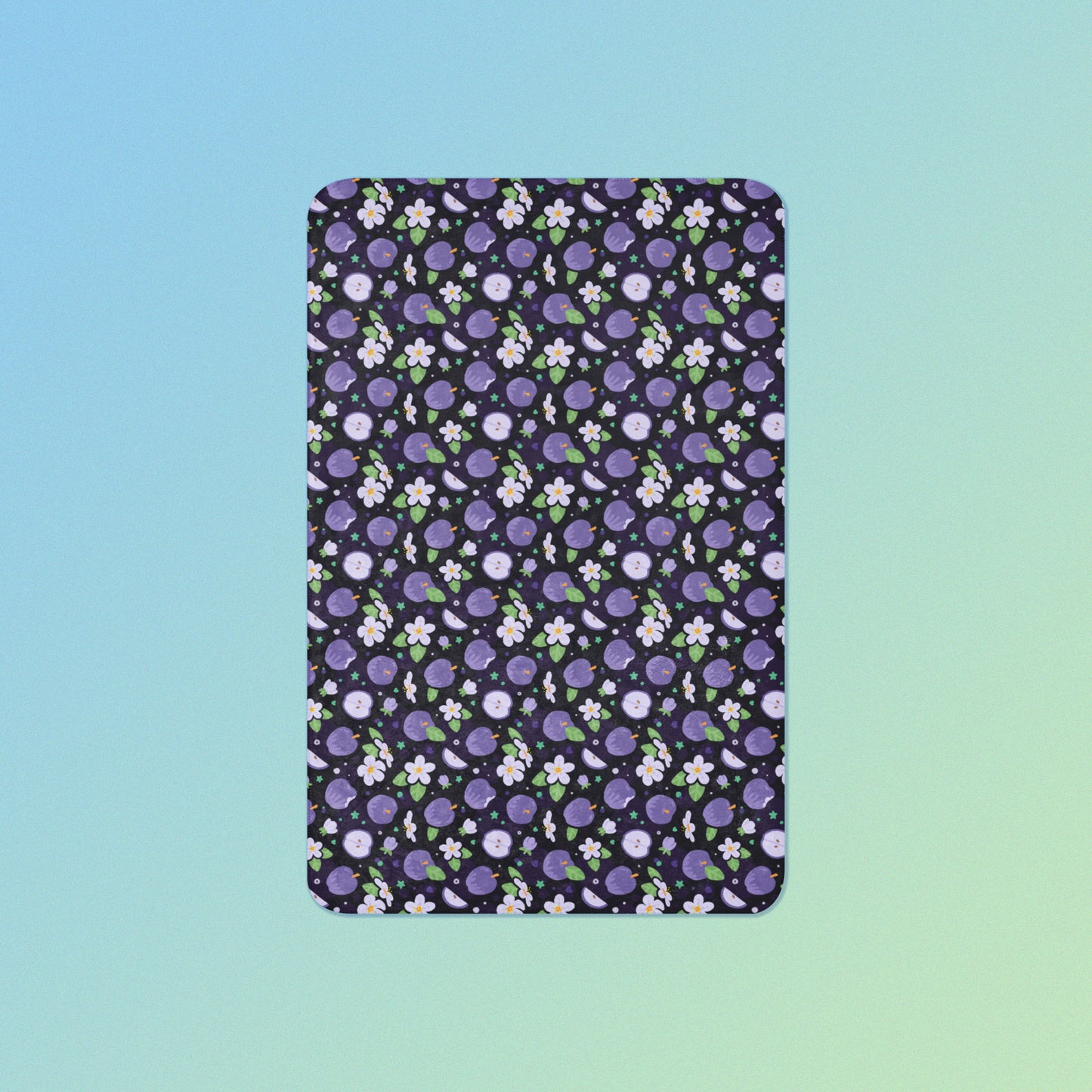 A purple apples & blossoms pattern blanket on a blue and green gradient background.