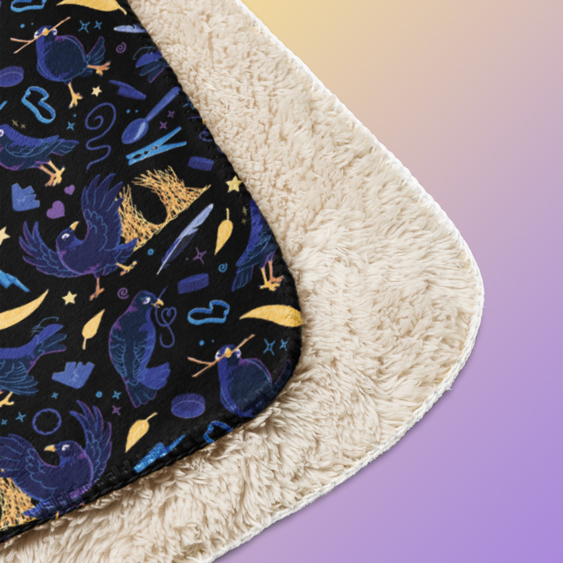 Close up detail of a folded black, blue, purple and yellow male Aussie satin bowerbird pattern blanket on a yellow and purple gradient background.