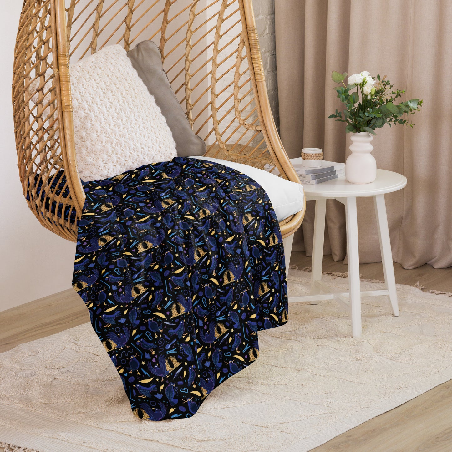 A black, blue, purple and yellow male Aussie satin bowerbird pattern blanket sitting on a swinging woven egg chair with soft, natural lighting.