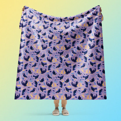 Person holding a purple, blue and yellow male Aussie satin bowerbird pattern blanket above their head on a yellow and blue gradient background.