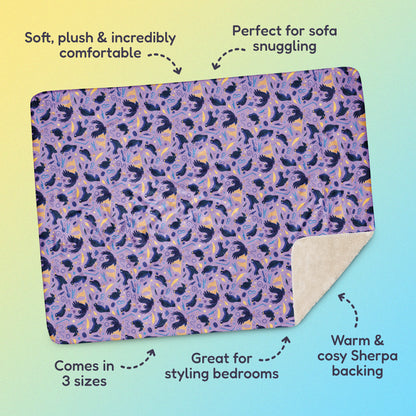 Features & benefits ('Soft, plush & incredibly comfortable', 'Perfect for sofa snuggling', 'Comes in 3 sizes', 'Great for styling bedrooms', 'Warm & cosy Sherpa backing') surrounding a purple, blue and yellow male Aussie satin bowerbird pattern blanket on a yellow and blue gradient background.