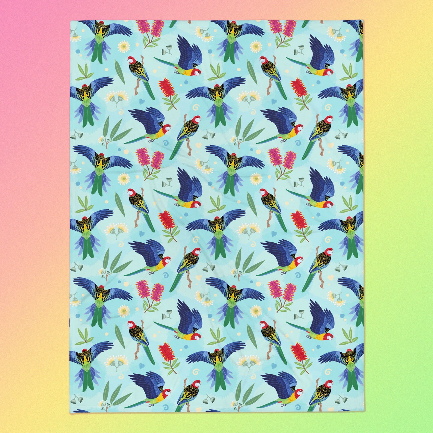 A blue, pink and green eastern rosella & native Aussie plant pattern blanket on a pink, yellow and green gradient background.