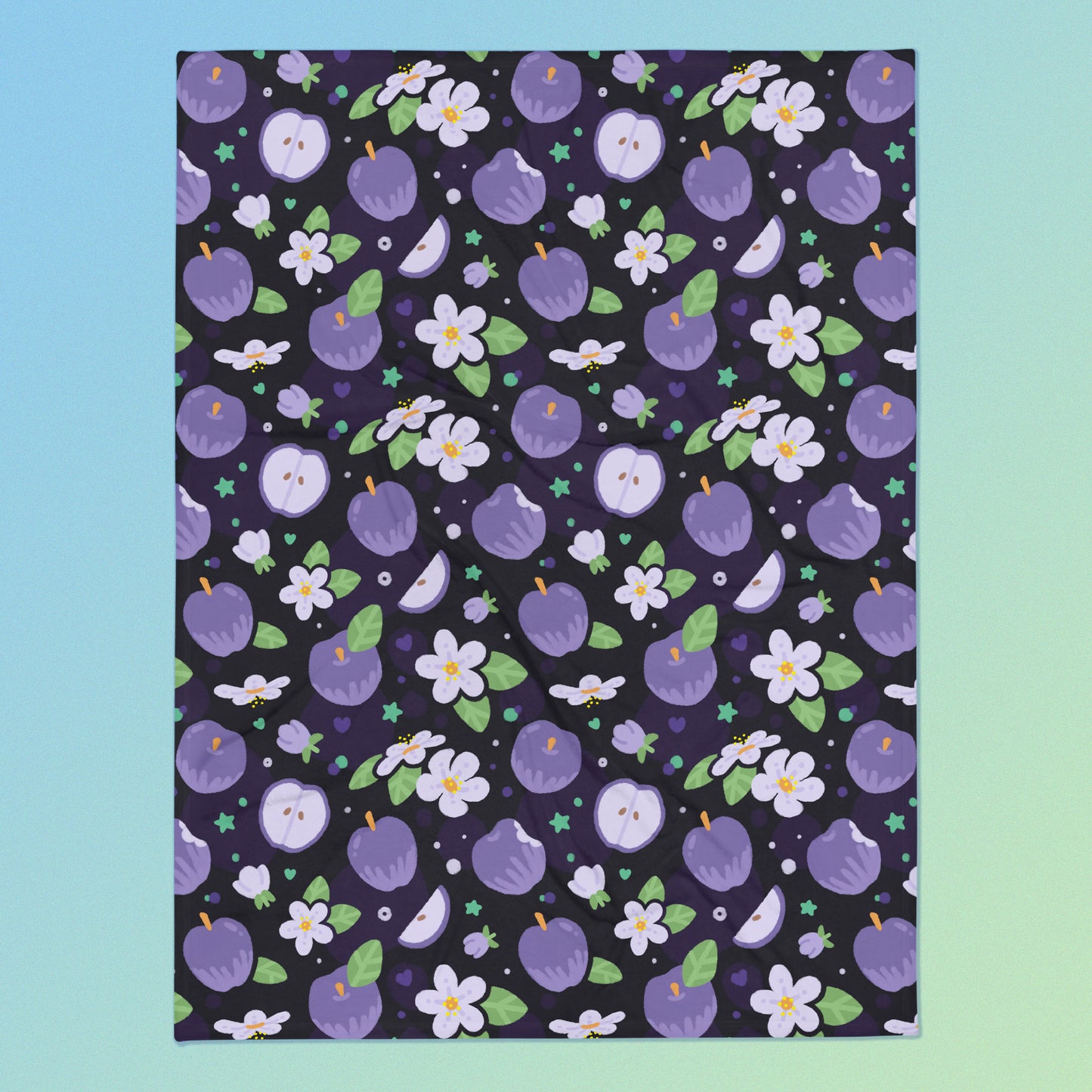 A purple apples & blossoms pattern blanket on a blue and green gradient background.