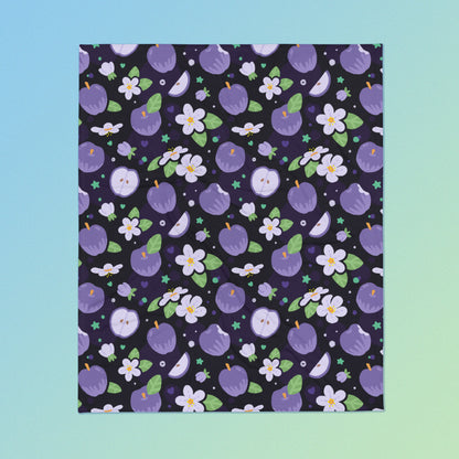 A purple apples & blossoms pattern blanket on a blue and green gradient background.
