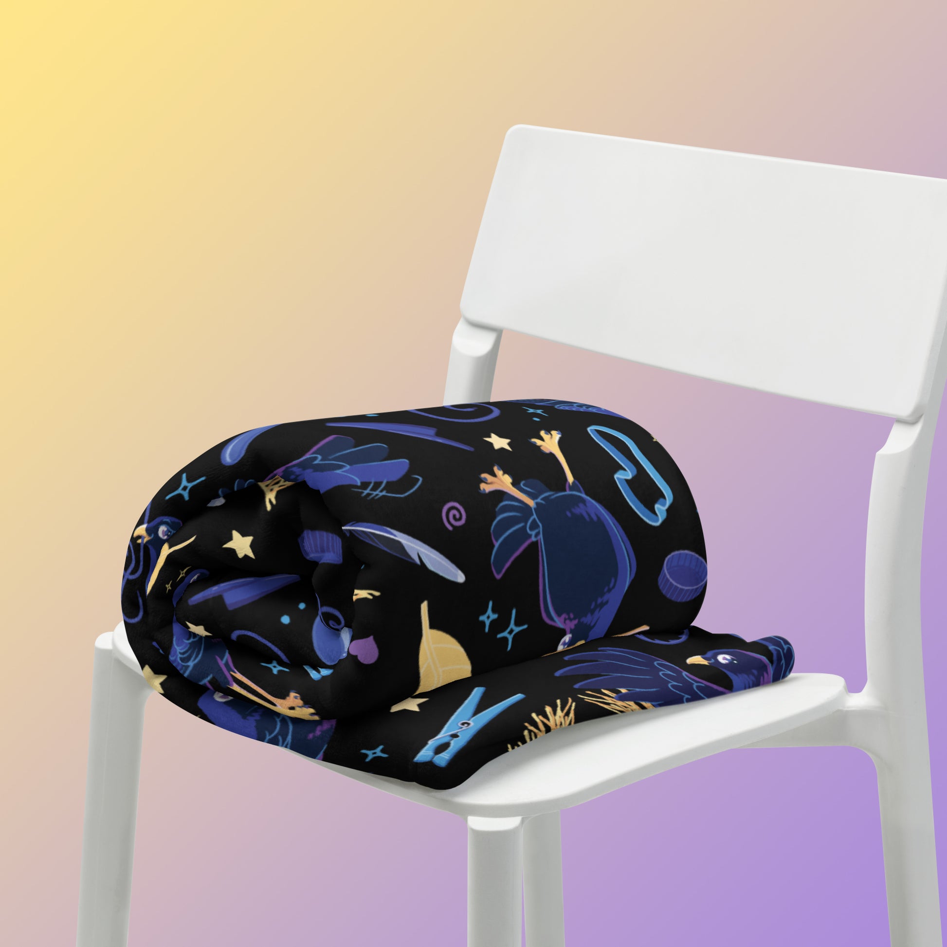 A rolled up black, blue, purple and yellow male Aussie satin bowerbird pattern blanket sitting on a white chair on a yellow and purple gradient background.