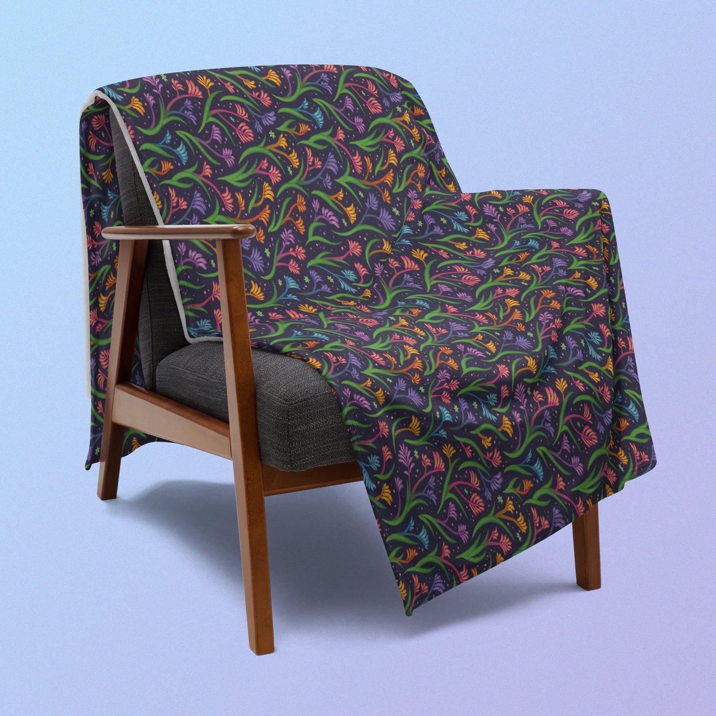 A rainbow kangaroo paw flower pattern blanket draped over a wooden chair on a blue and purple gradient background.
