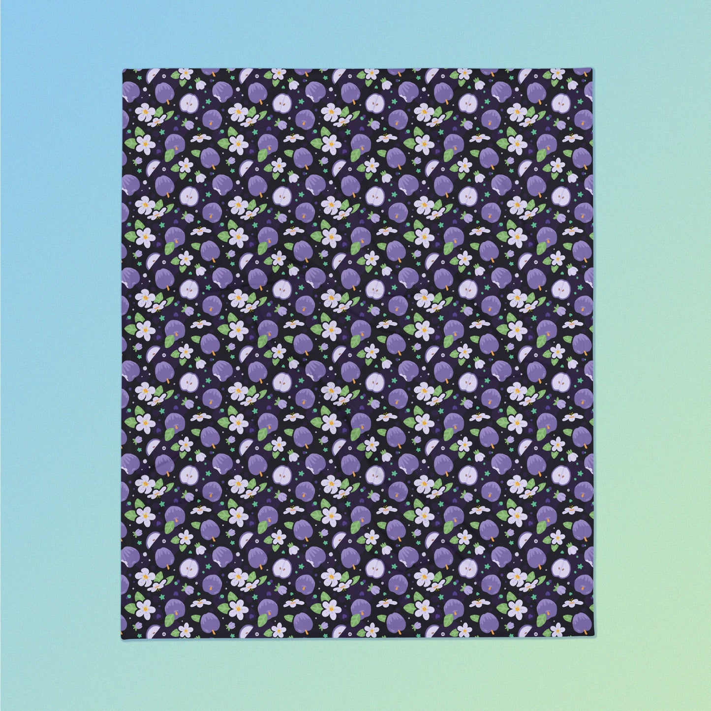 A purple apples & blossoms pattern blanket on a blue and green gradient background.