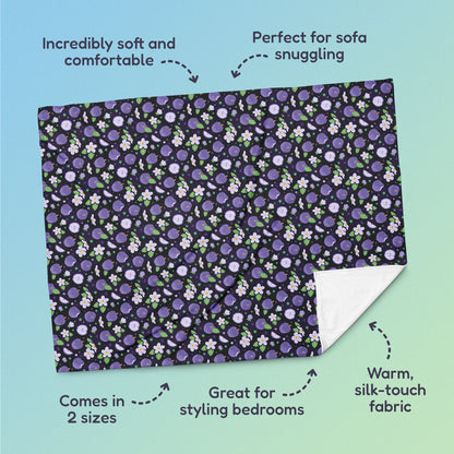 Features & benefits (Incredibly soft & comfortable', 'Perfect for sofa snuggling', 'Comes in 2 sizes', 'Great for styling bedrooms', 'Warm silk-touch fabric') surrounding a purple apples & blossoms pattern blanket on a blue and green gradient background.