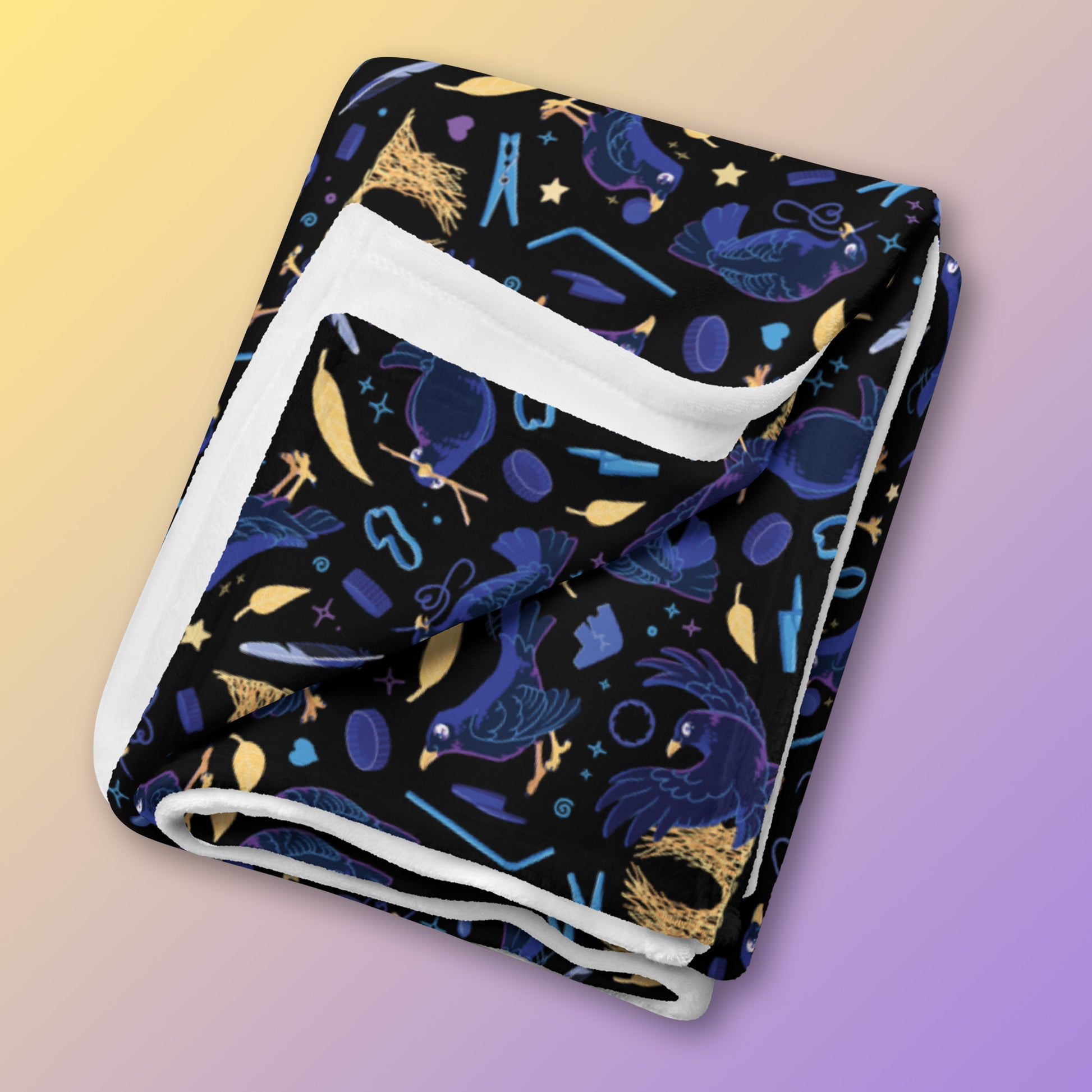 A folded black, blue, purple and yellow male Aussie satin bowerbird pattern blanket on a yellow and purple gradient background.