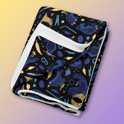 A folded black, blue, purple and yellow male Aussie satin bowerbird pattern blanket on a yellow and purple gradient background.