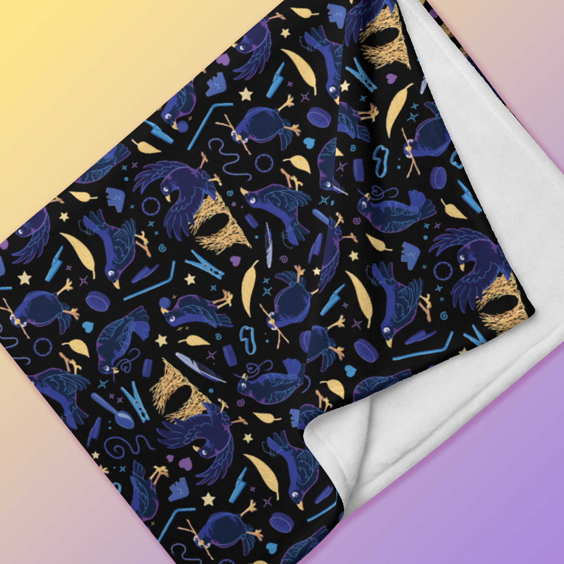 Close up detail of a folded black, blue, purple and yellow male Aussie satin bowerbird pattern blanket on a yellow and purple gradient background.
