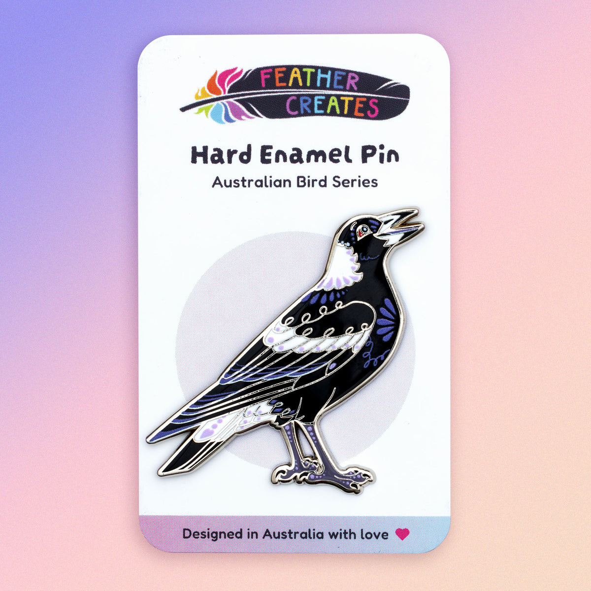 A nickel-plated Australian magpie hard enamel pin sitting on a 'Feather Creates' branded backing card on a blue, purple and pink gradient background.