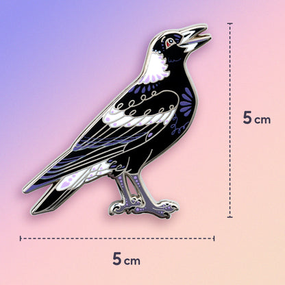 5x5cm nickel-plated Australian magpie hard enamel pin on a blue, purple and pink gradient background.