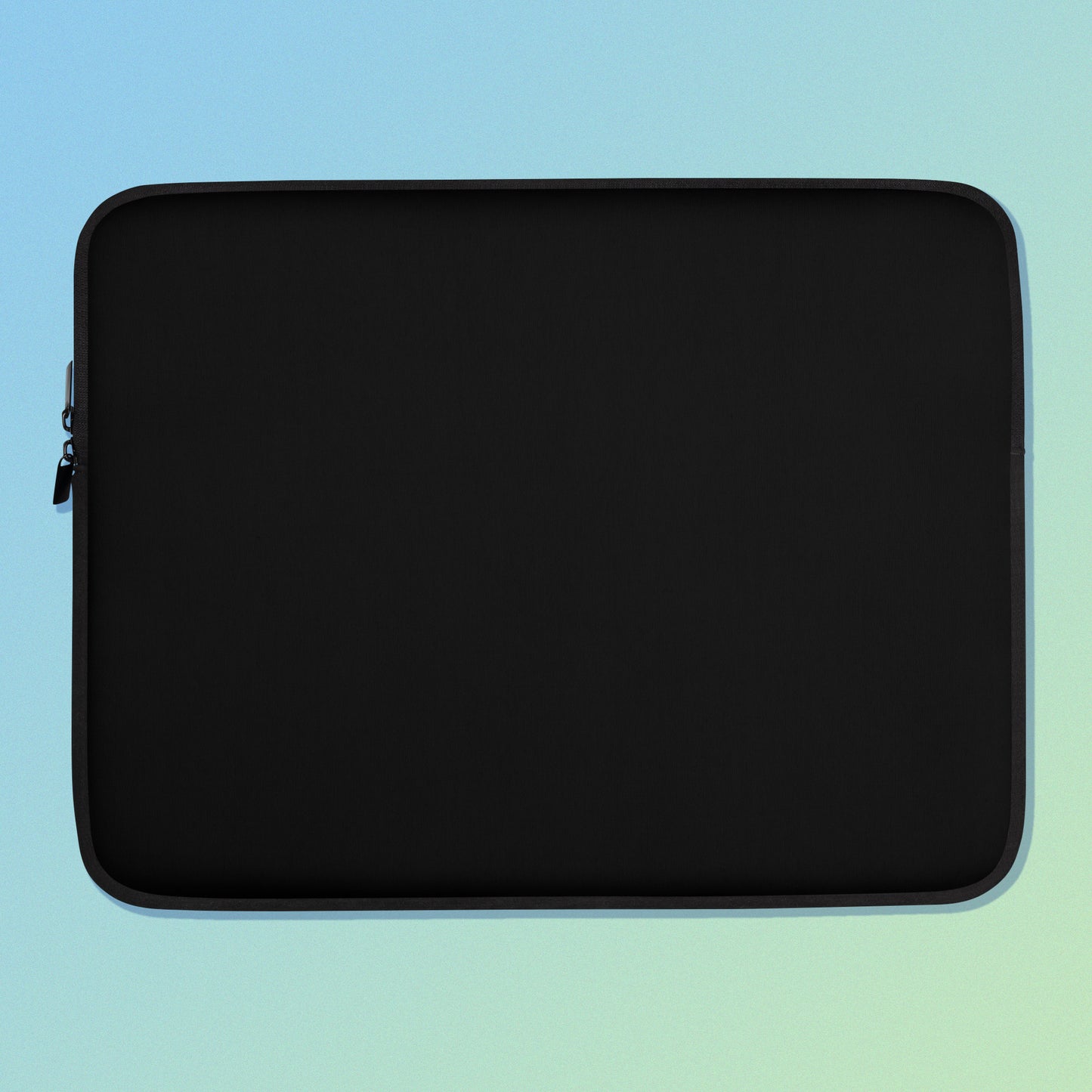 Laptop sleeve with plain black fabric on one side and a colourful purple apples and apple blossoms pattern on the other on a blue and green gradient background.