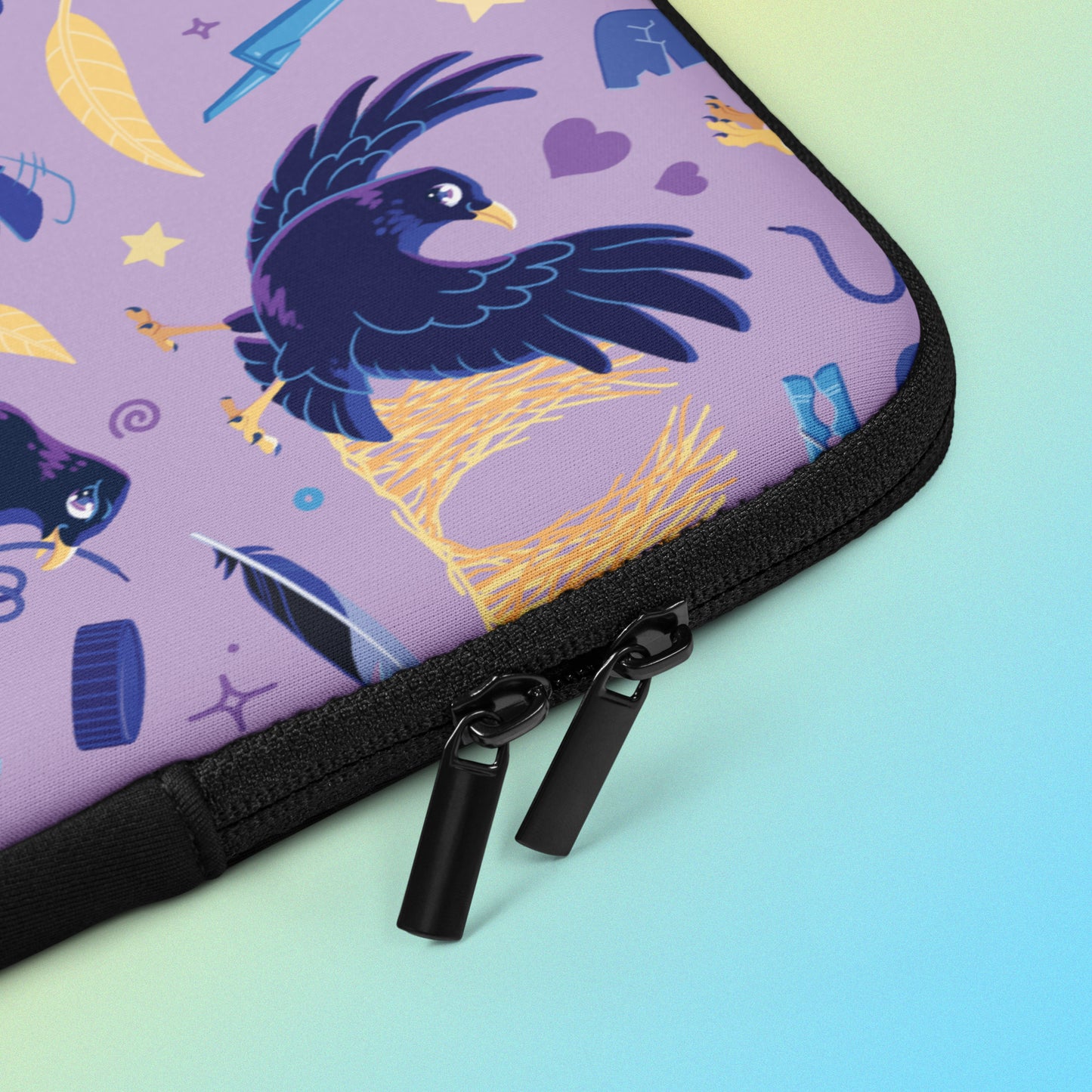 Close up detail of a laptop sleeve with a colourful purple, blue and yellow satin bowerbird pattern on a yellow and blue gradient background.