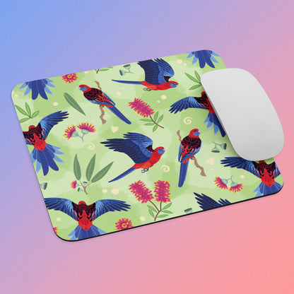 Mouse pad with crimson rosella parrot design and a white mouse on a blue-pink gradient background
