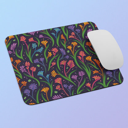 Colourful floral kangaroo paw themed mouse pad with a white mouse on a light blue background