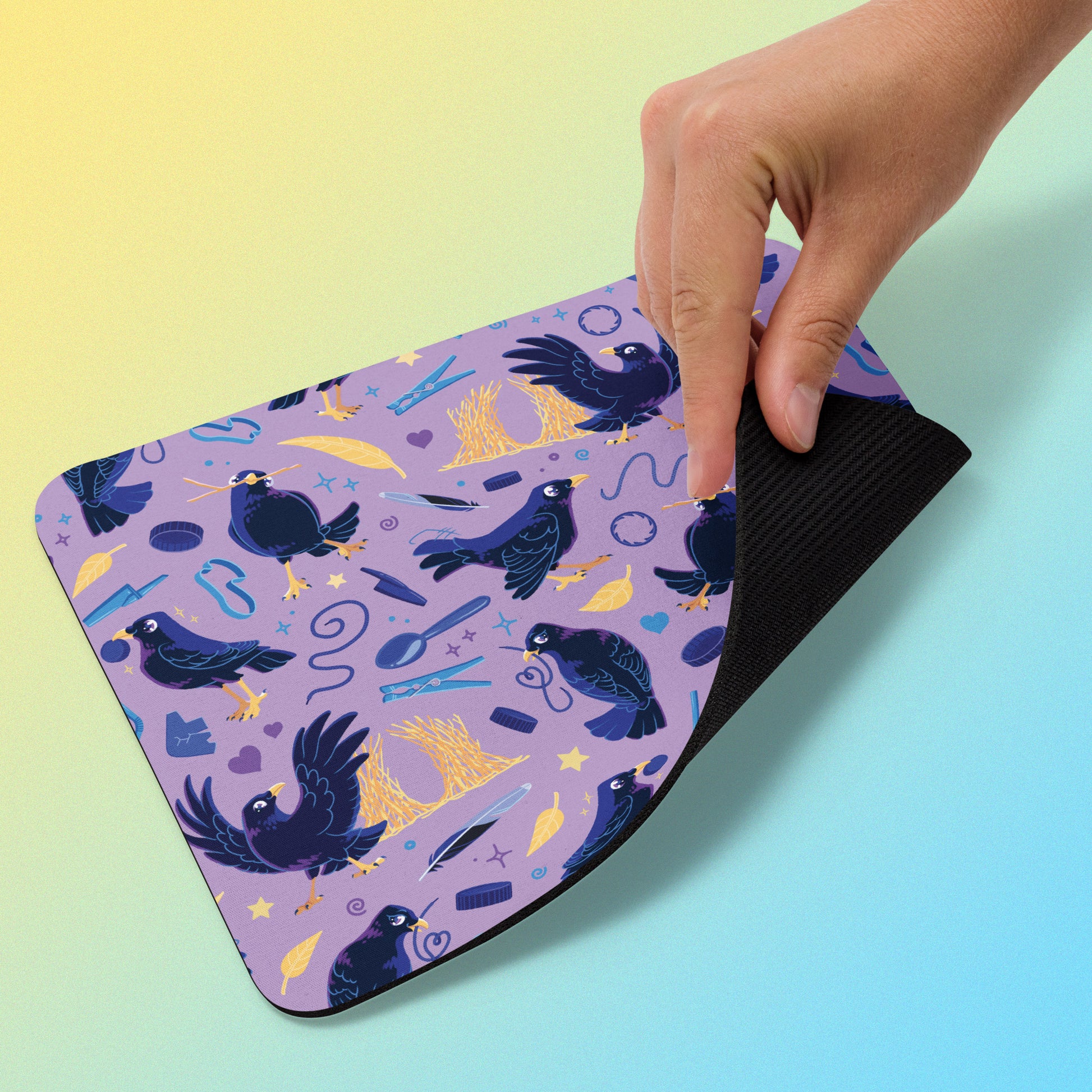 Purple mouse pad with a satin bowerbird pattern held by a hand on a gradient background