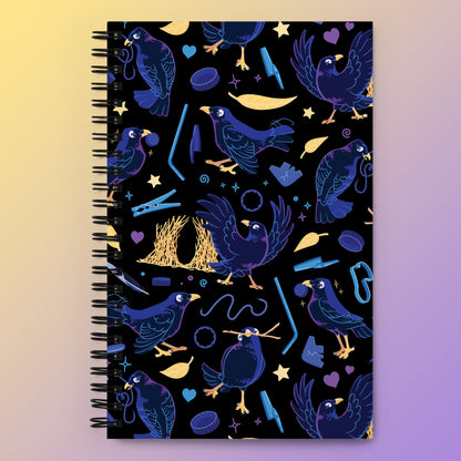 Spiral notebook with a colourful purple, blue and yellow satin bowerbird pattern on a yellow and purple gradient background.