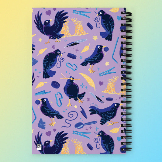 Spiral notebook with a colourful purple, blue and yellow satin bowerbird pattern on a yellow and blue gradient background.