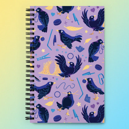 Spiral notebook with a colourful purple, blue and yellow satin bowerbird pattern on a yellow and blue gradient background.