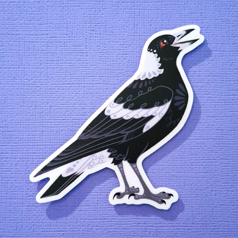 Real photo of a cute and decorative Australian magpie sticker on a purple canvas textured background.