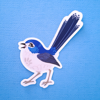 Real photo of a colourful sticker of a female Lovely Fairywren chirping on a blue canvas textured background.