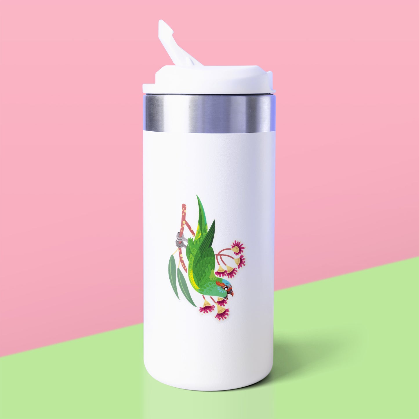 Colourful sticker of a musk lorikeet perched amongst pink eucalyptus flowers stuck to a white metal drink bottle on a green table on a pink background.